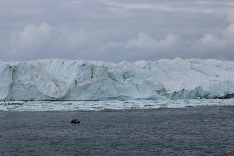A boat approaches a shelf of ice in Antarctica.
